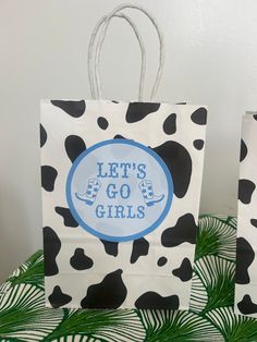 two black and white bags with blue lettering on them sitting on top of a table