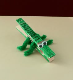 a toy made to look like an alligator with eyes on it's head and legs