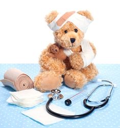 a teddy bear with bandages and a stethoscope sitting on top of a table