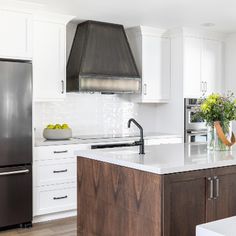 a kitchen with white cabinets and an island in front of a stove top oven that has flowers on it