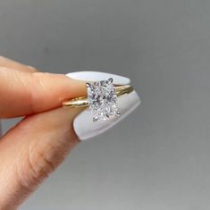 a person holding a diamond ring in their hand