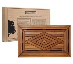 a wooden box with an intricate design on the front and side, next to it's cardboard package