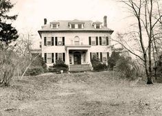 an old black and white photo of a large house in the middle of some trees