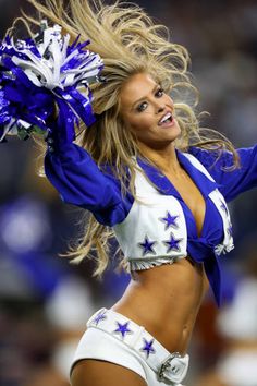 a cheerleader in blue and white is dancing