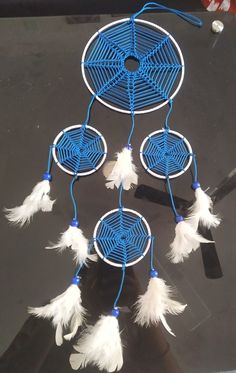 a blue and white dream catcher with feathers