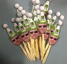 a bunch of sticks with faces on them and golf balls in the middle one is wearing sunglasses