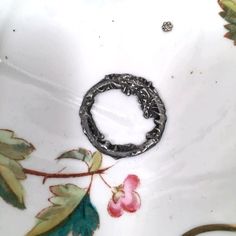 a close up of a bowl with flowers on it and a ring in the middle