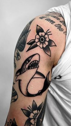 a man's arm with tattoos on it and a shark in the middle of his arm