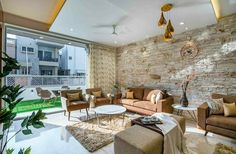 a living room filled with furniture next to a large glass window covered in greenery