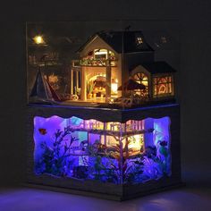 a doll house is lit up in the dark with blue lights and plants on top