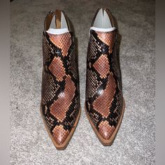 A Split Shaft Adds A Distinctive, Modern Touch To A Pointy-Toe Bootie Set On A Lofty Stacked Heel. - Pointed Toe - Covered Vamp - Snakeskin Embossed Upper - Back Zip Closure - Notched Sides - Stacked Block Heel Western Style Medium Width Heels With Pointed Toe, Leather Boots With Snake Print For Spring, Brown Pointed Toe Heels With Heel Pull Tab, Snake Print Leather Boots With Pointed Toe, Brown Heels With Medium Width And Snip Toe, Snake Print Boots With Medium Width And Almond Toe, Snake Print Boots With Almond Toe And Medium Width, Western Brown Ankle Boot Heels, Brown Western Ankle Boot Heels