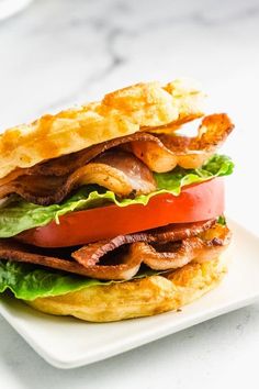 a bacon, tomato and lettuce sandwich on a white plate