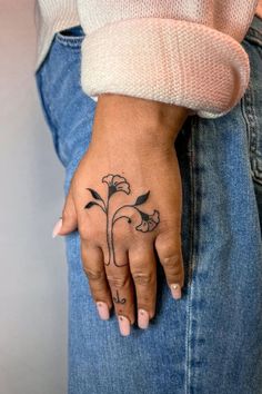 a woman's hand with a flower tattoo on it