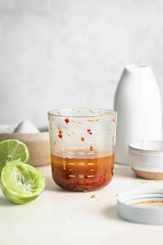 the ingredients for an iced drink sit on a counter next to a blender and limes