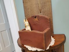 a wooden box sitting on top of a table next to a white lace doily