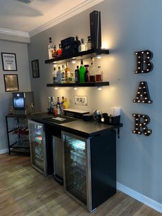 Shelves are from IKEA, Mini Fridge from Target, Bar LED sign from Amazon Bar Cooler Ideas, Mini Bar For Home, Loft Area Ideas Upstairs Bar, Wine In Living Room, Bar And Movie Room Basement Ideas, Living Room With Gaming Area, Diy Bar Area Living Room, Theater Room Bar Ideas, In Home Mini Bar