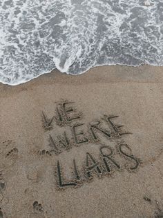 there is a message written in the sand at the beach that says we were liars