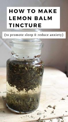 a jar filled with lemon balm tincture sitting on top of a wooden table