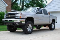 a silver truck parked in front of a house