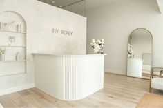 a white reception area with flowers on the counter