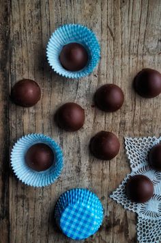 some chocolates are sitting on a table next to a blue cupcake wrapper