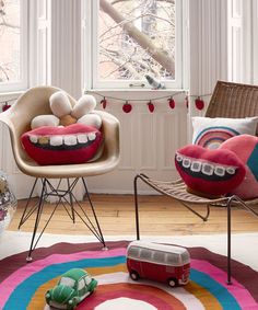 a living room filled with furniture and toys on top of a colorful rug in front of a window