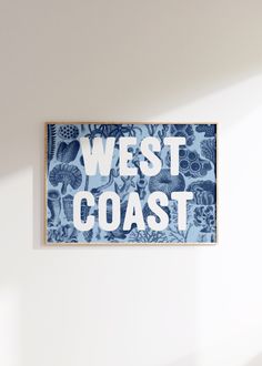 a blue and white sign that says west coast hanging on the wall in an empty room