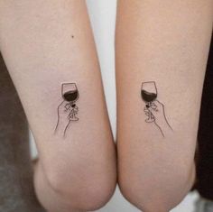 two people holding wine glasses on their legs, one has a small tattoo on it