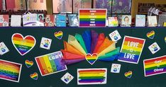 a bulletin board with rainbows, hearts and love notes on it in front of bookshelves