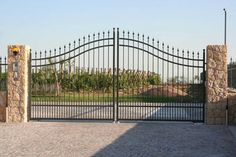 an iron gate with stone pillars and gates