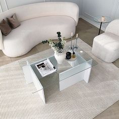 a living room with two white couches and a coffee table