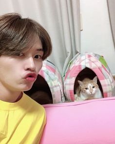 a young man sitting in front of a cat