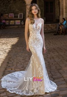 a woman in a white wedding dress standing on a brick floor with her hand on her hip