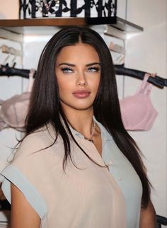 a woman with long hair standing in front of clothes