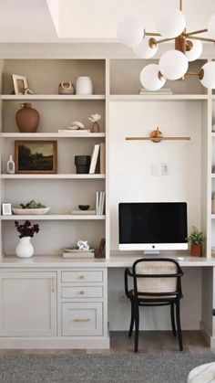 a home office with built - in shelving units and a computer on the desk