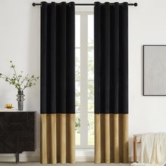 a black and gold curtain hanging in front of a window with a white rug on the floor