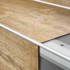 a close up view of a wooden counter top with a metal handle on the door