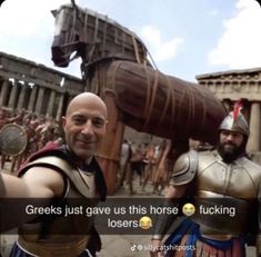 two men dressed in roman costumes standing next to each other and pointing at the camera