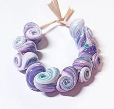 a bracelet made out of glass beads on a white surface