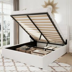 an open white bed frame with books on it in front of a window and rug