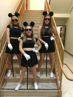 three girls dressed up as mickey mouse and minnie mouse ears on the steps in front of some stairs