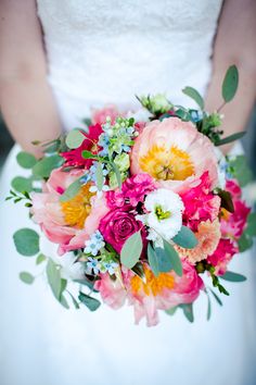 a bridal holding a bouquet of flowers and greenery