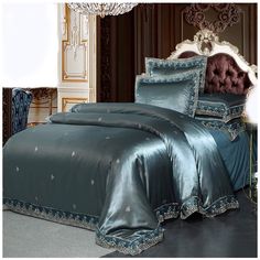 a bed with blue comforter and pillows in a room next to a chandelier