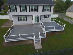 an aerial view of a two story house with white railings and steps leading to the front door