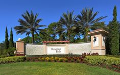 the entrance sign to an apartment complex with palm trees in the background and landscaping around it