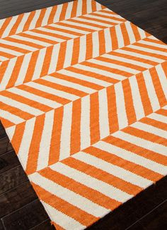 an orange and white rug on a wooden floor