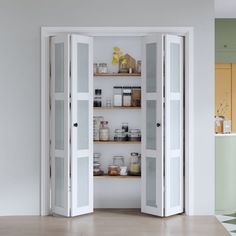 an open pantry door in the middle of a room with shelves and jars on it