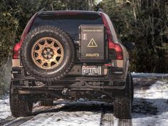 the back end of a black truck parked on snow covered ground