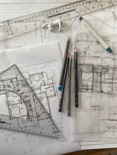 architectural drawings and pencils on top of paper