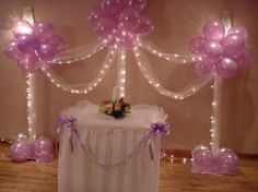 the table is set up with balloons and flowers